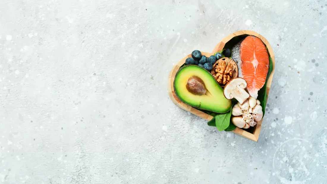 foods-good-heart-nuts-salmon-avocados-spinach-mushrooms-berries-heartshaped-box-stone-background-top-view-copy-space